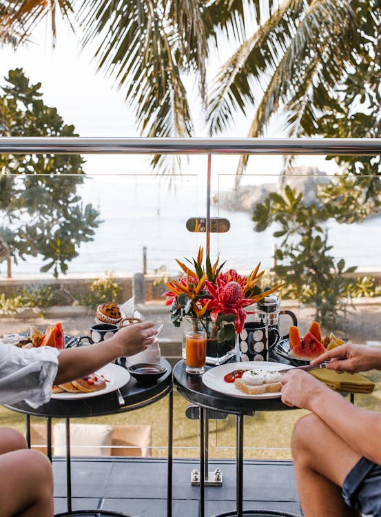 Young couple having breakfast on terrace during romantic trip