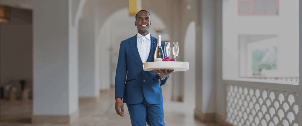 Sandals Resort Butler holding Bottle of Champagne and wine glasses