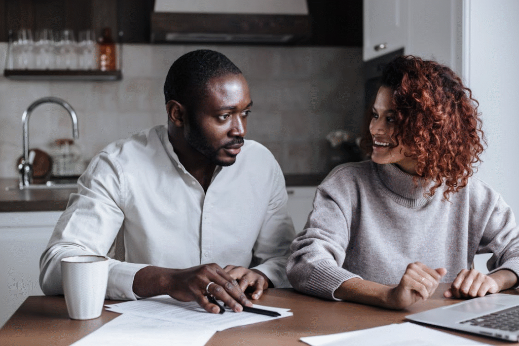 Couple collaborating on wedding guest list at their kitchen table