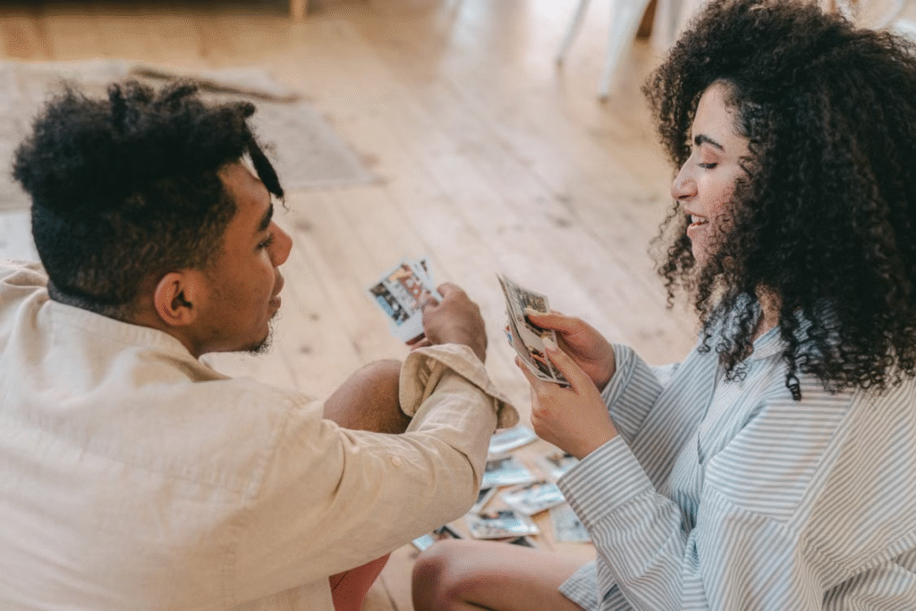 Happy couple sharing and enjoying personal photos indoors, capturing precious memories.