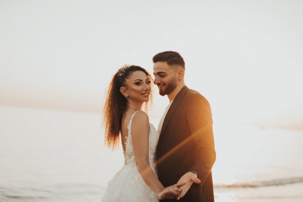Happy newlyweds embracing during a sunset at the beach